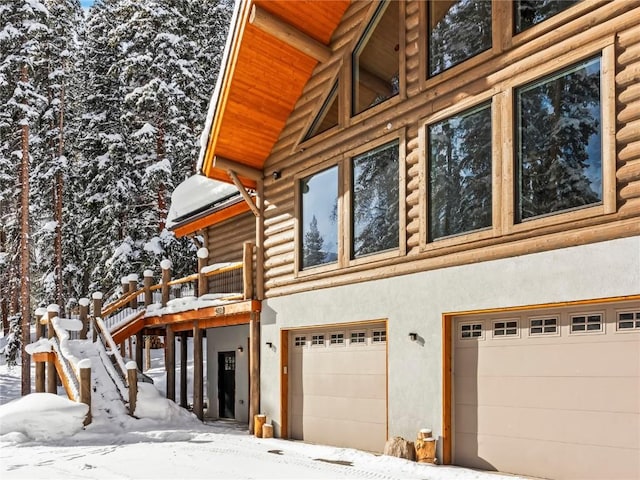 view of snowy exterior with a garage