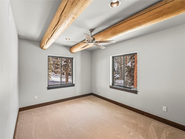 carpeted empty room with ceiling fan and beam ceiling