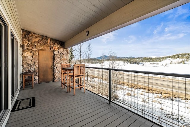 snow covered deck featuring a mountain view