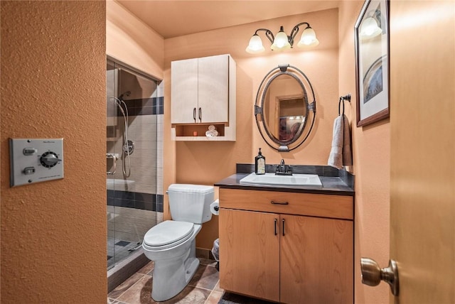 bathroom featuring a shower stall, toilet, and vanity