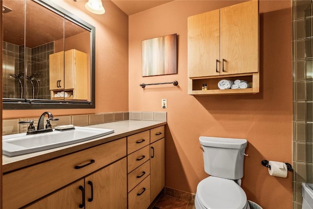 bathroom with vanity, toilet, baseboards, and walk in shower