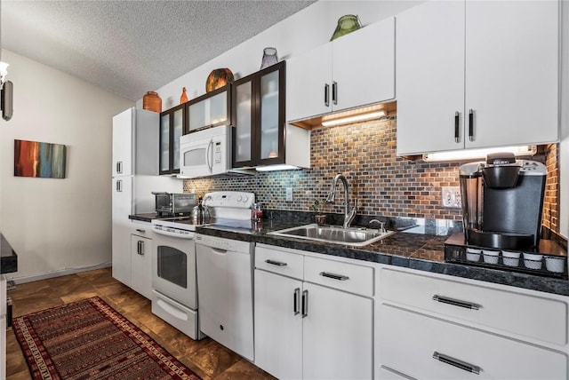 kitchen with white appliances, a sink, decorative backsplash, glass insert cabinets, and a textured ceiling