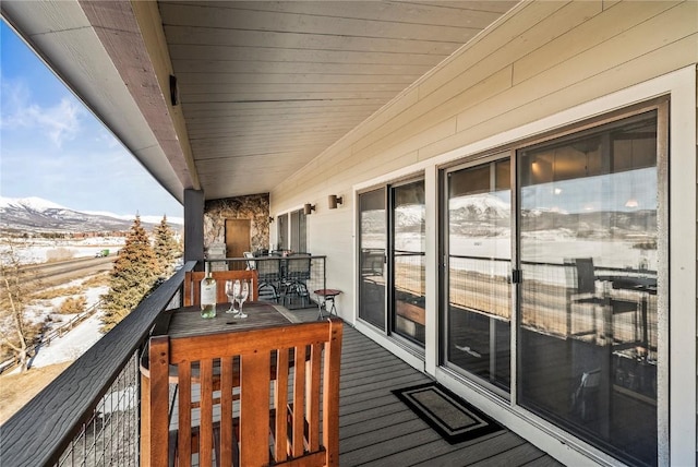 snow covered back of property with a mountain view