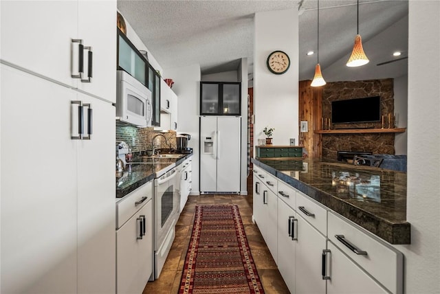 kitchen with pendant lighting, decorative backsplash, white cabinets, white appliances, and a textured ceiling