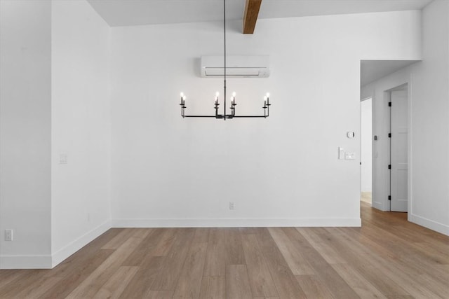 unfurnished dining area with an AC wall unit, a notable chandelier, beam ceiling, and light hardwood / wood-style flooring