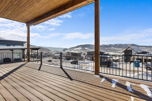 snow covered deck with a mountain view