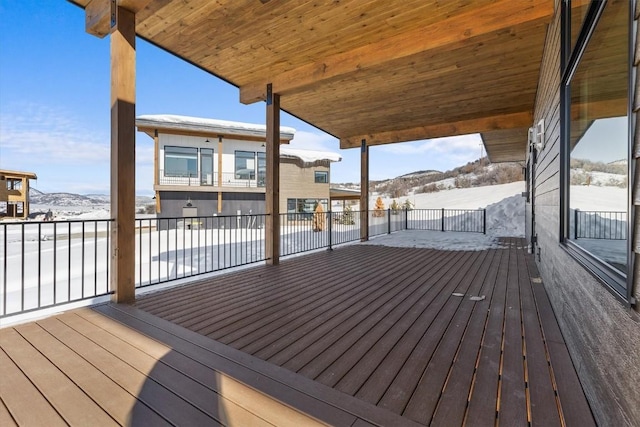 snow covered deck with a mountain view