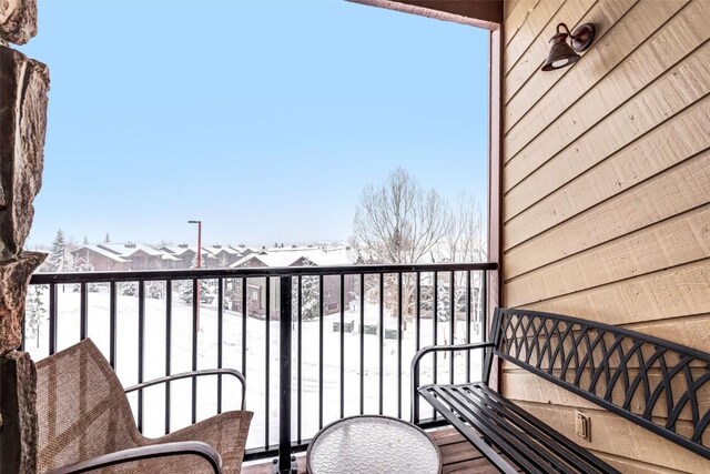 view of snow covered back of property