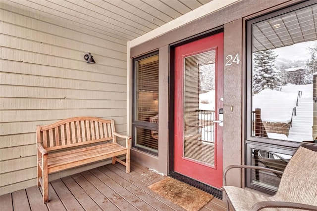 snow covered property entrance featuring a porch