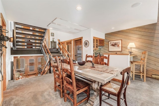 carpeted dining room with wooden walls