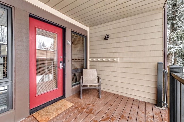 snow covered property entrance featuring covered porch