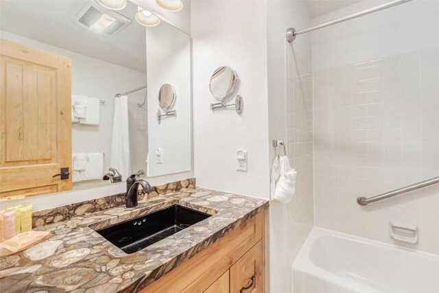 bathroom featuring vanity and shower / bathtub combination with curtain