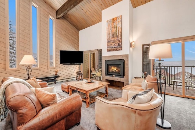 living room featuring beam ceiling, a tiled fireplace, high vaulted ceiling, and wooden ceiling