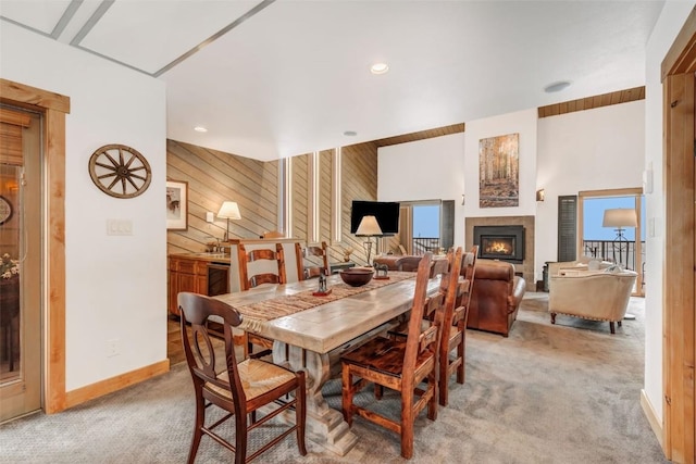 carpeted dining room with wood walls