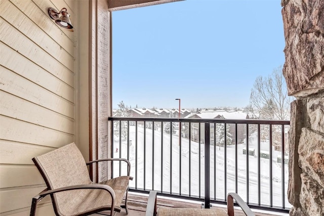 view of snow covered back of property