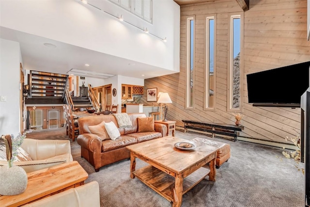 carpeted living room with track lighting and wooden walls