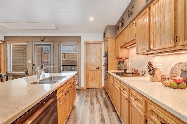 kitchen with black appliances, light hardwood / wood-style flooring, sink, and tasteful backsplash