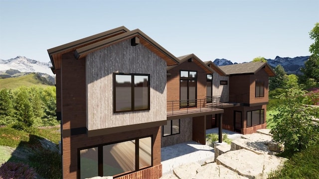 rear view of house featuring a patio area, a balcony, and a mountain view