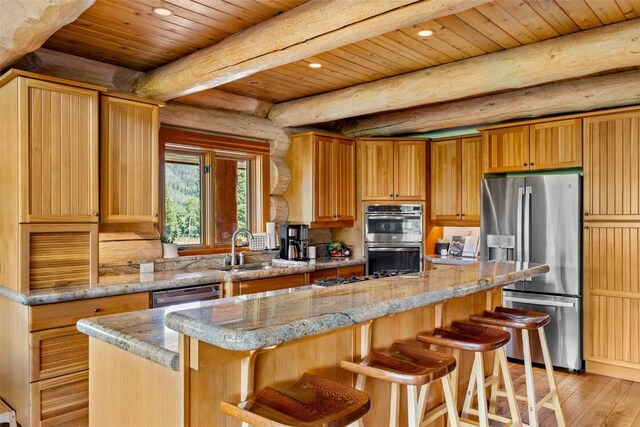 kitchen featuring appliances with stainless steel finishes, light wood-type flooring, wood ceiling, sink, and a center island