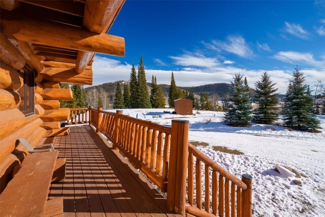 snow covered deck featuring a mountain view