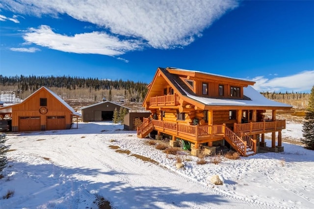 cabin featuring an outbuilding, covered porch, and a garage