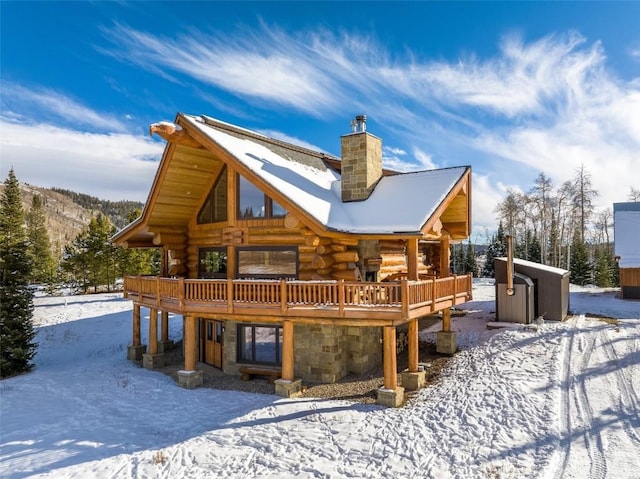 snow covered house featuring a deck