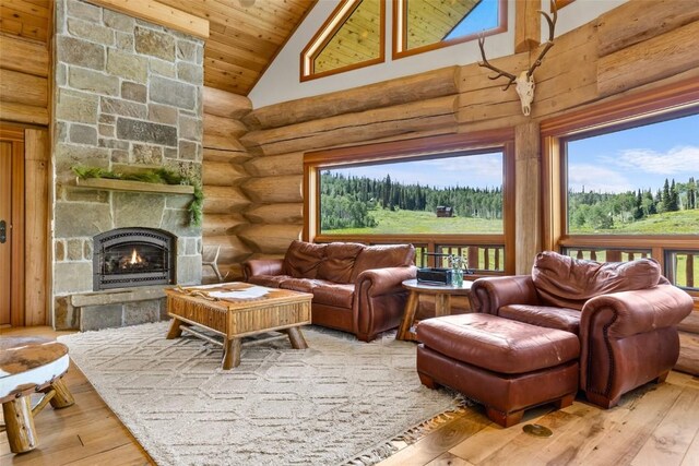 sunroom featuring a stone fireplace, lofted ceiling, and wood ceiling