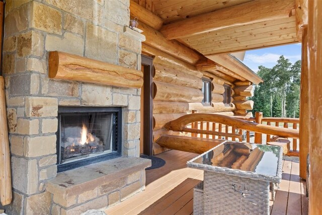 interior details featuring an outdoor stone fireplace and rustic walls