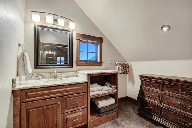 bathroom featuring vanity and lofted ceiling