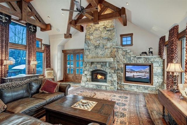 living room with hardwood / wood-style flooring, beam ceiling, a fireplace, and high vaulted ceiling