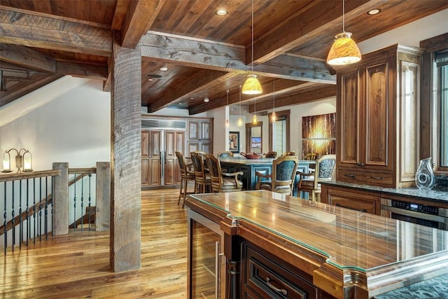 kitchen with beverage cooler, beamed ceiling, pendant lighting, light hardwood / wood-style floors, and wood ceiling