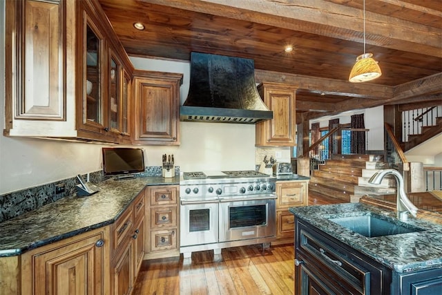 kitchen with premium range hood, dark stone counters, sink, double oven range, and wooden ceiling