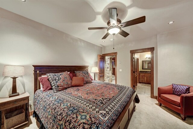 bedroom with ensuite bathroom, ceiling fan, and light carpet