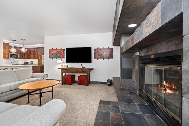 carpeted living room featuring a tile fireplace