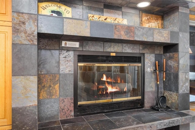 interior details featuring a tile fireplace