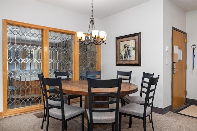 dining area featuring carpet flooring and a chandelier