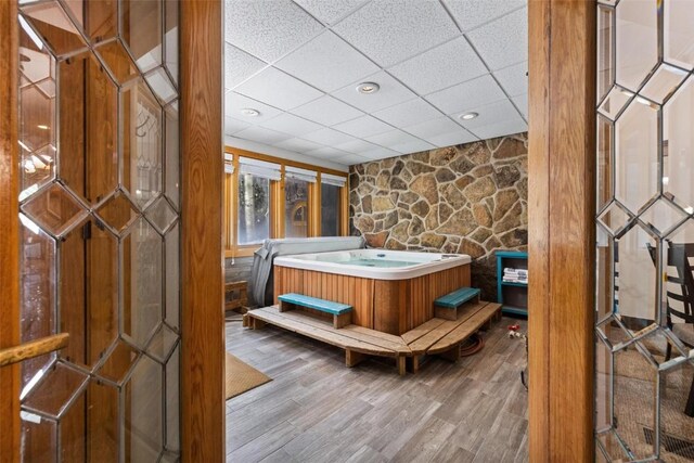 interior space with a drop ceiling and hardwood / wood-style floors