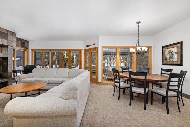 carpeted living room featuring an inviting chandelier and a fireplace