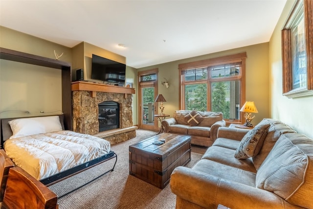 living room with carpet flooring and a stone fireplace