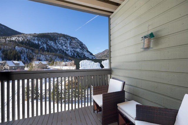 snow covered deck featuring a mountain view