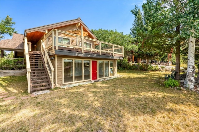 rear view of house with a deck and a lawn