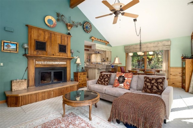 carpeted living room with beamed ceiling, high vaulted ceiling, and ceiling fan with notable chandelier