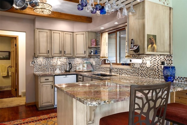 kitchen featuring a breakfast bar, sink, light stone counters, dark hardwood / wood-style flooring, and backsplash