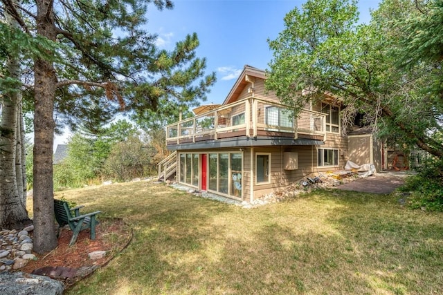 back of property with a yard and a sunroom