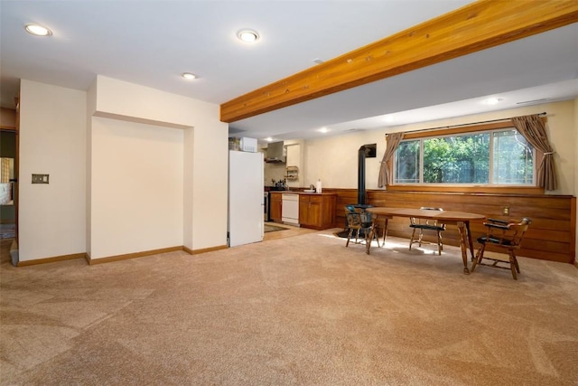 interior space with beamed ceiling and a wood stove