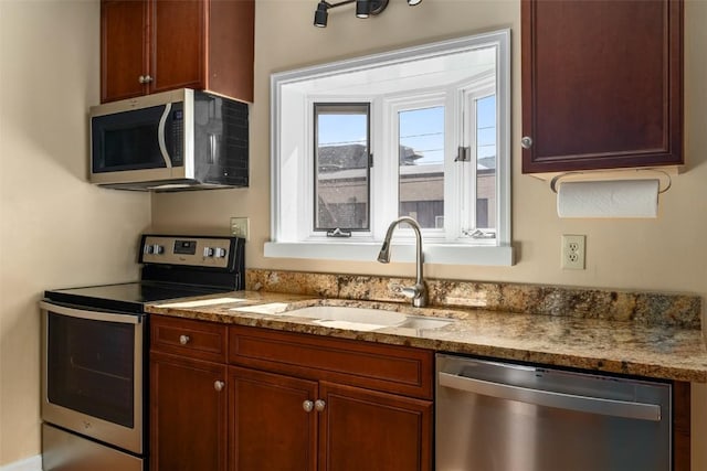 kitchen featuring light stone countertops, sink, and appliances with stainless steel finishes