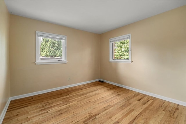 unfurnished room with light hardwood / wood-style floors and a wealth of natural light