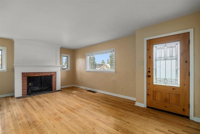 entrance foyer featuring a fireplace and light wood-type flooring