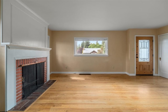 unfurnished living room with a fireplace and light hardwood / wood-style flooring