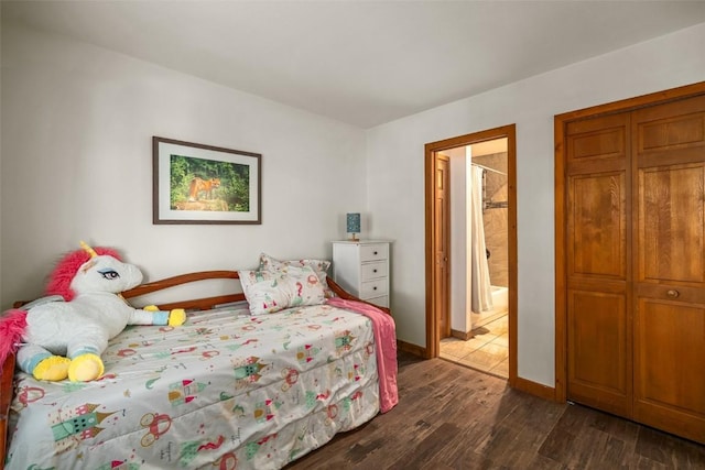 bedroom with dark hardwood / wood-style flooring and ensuite bath